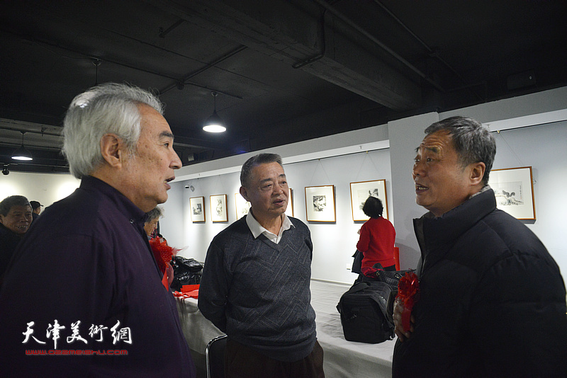 马明、邢立宏、王毓民在画展现场交流。