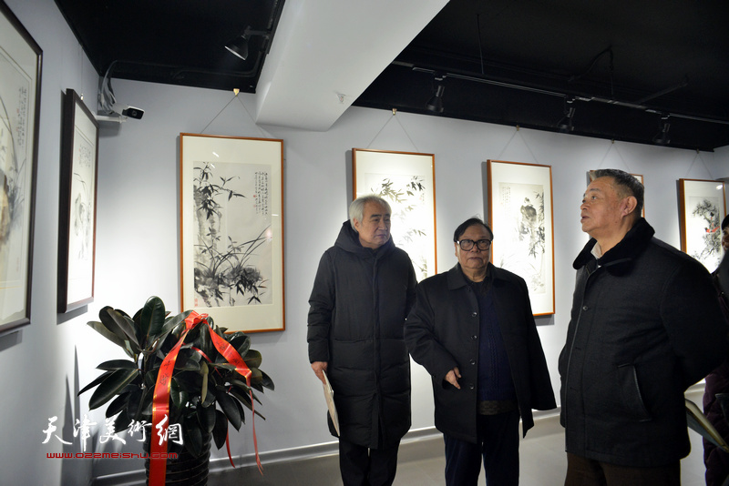 张浦生、马明、王毓民观看展出的作品。