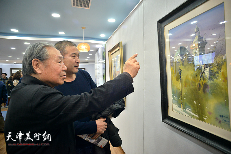 李宗儒、李金玺在观赏展出的水彩作品。