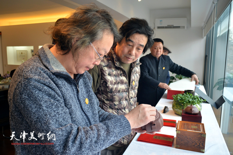 北京湖社画家张耀来、董振智观赏湖社品牌的文房用品。