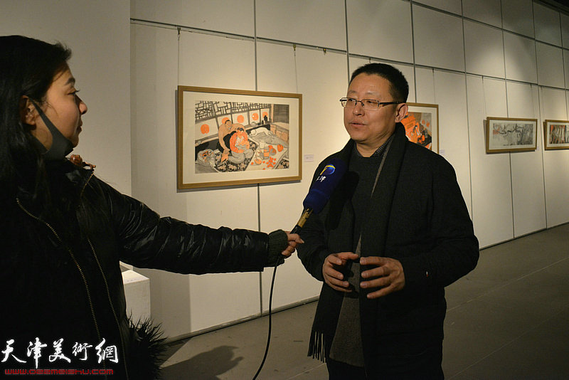 参展画家李晶彬在画展现场接受媒体采访。