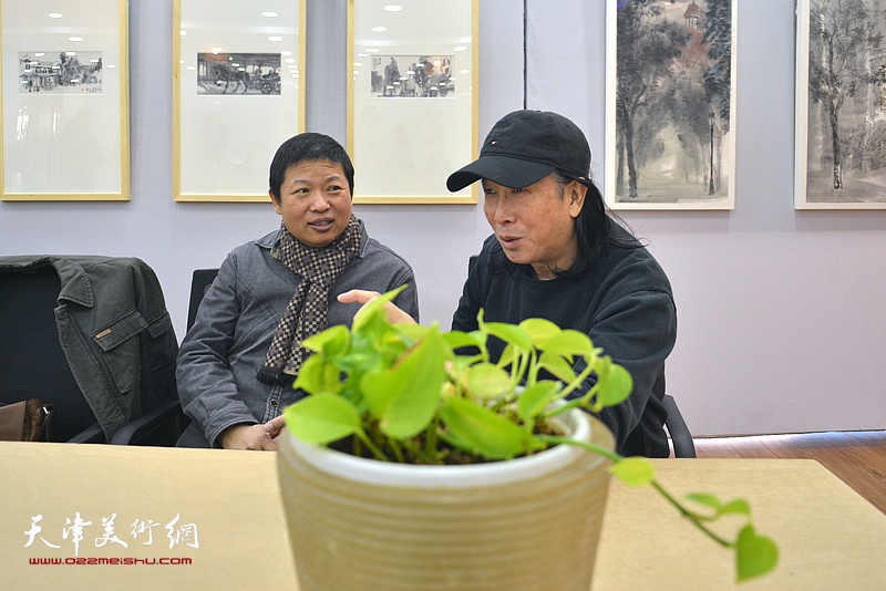 魏瑞江与周世麟在画展现场交流。