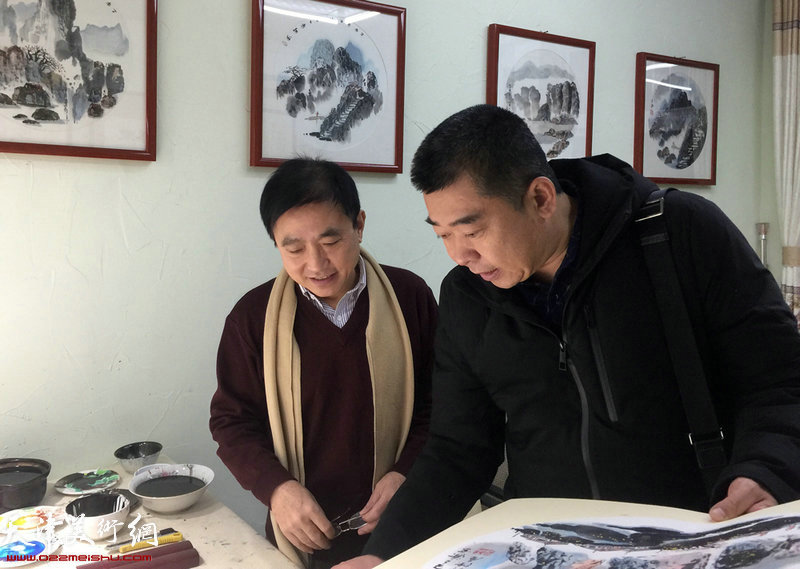 王文元向来宾介绍他创作的水墨作品。