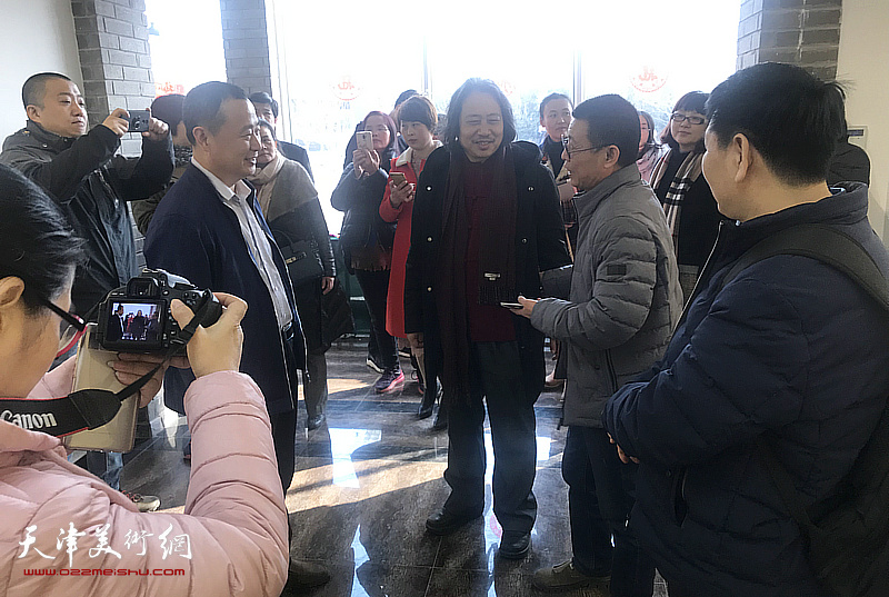 贾广健与周浩、张玉华在画展现场交谈。