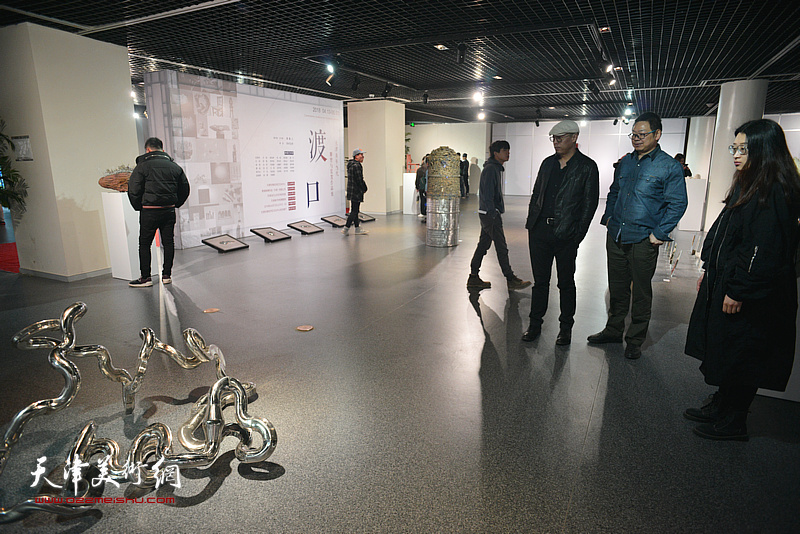谭勋、黄文智在画展现场观赏王凯的作品。