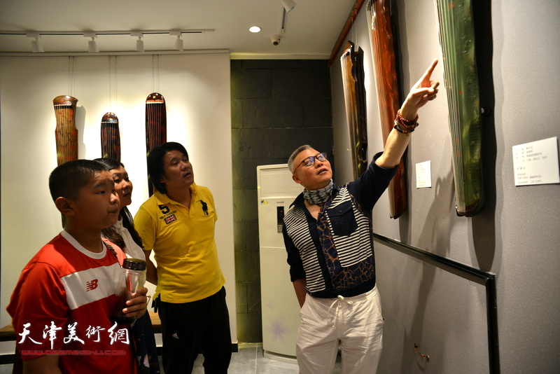 张国俊与观众观赏展出的古琴。