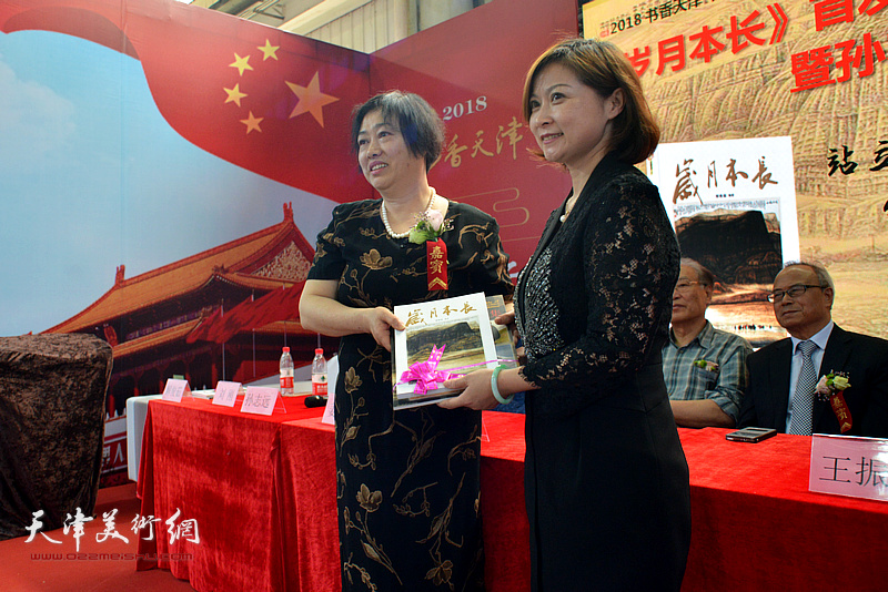 编著解俊茹女士向天津工艺美院图书馆馆长李连媚赠书。