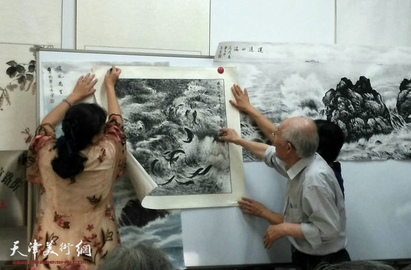 郭文伟在展示焦墨花鸟海洋画