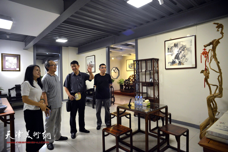 杨沛璋、陈福春与嘉宾在画展现场观赏展品。