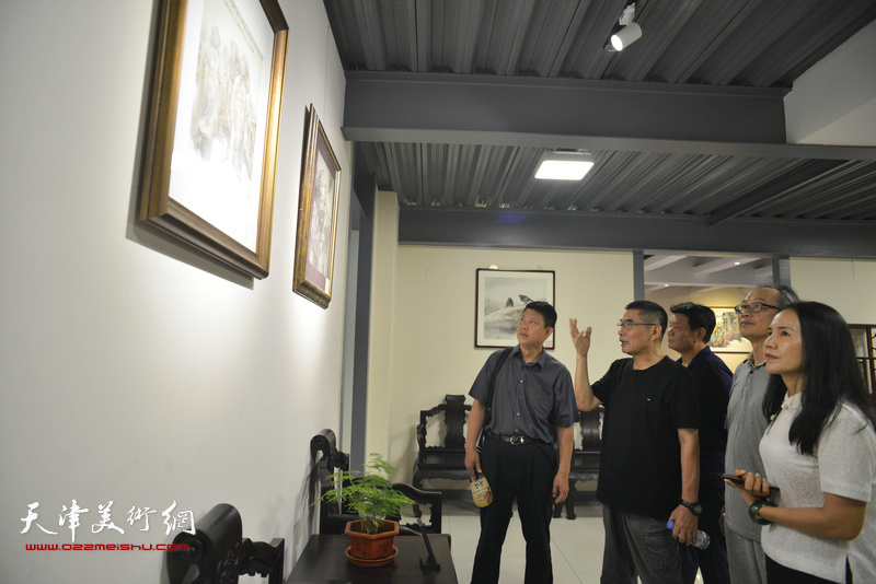 杨沛璋、陈福春与嘉宾在画展现场观赏展品。