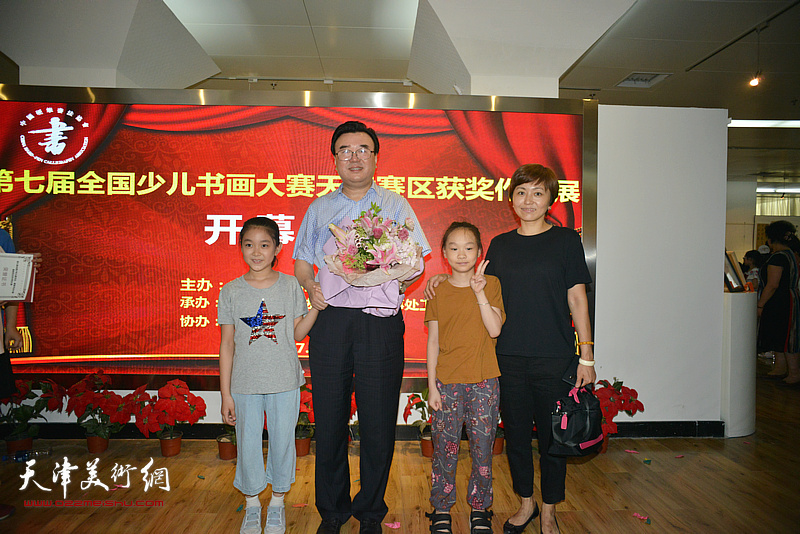 中国硬笔书法协会主席张华庆与获奖小艺术家们在画展现场。