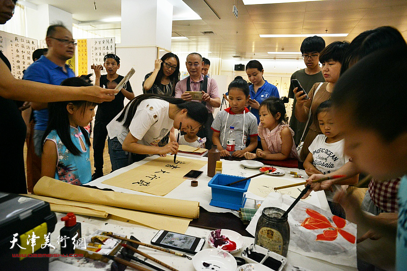 指导教师在展览现场书法书写示范。