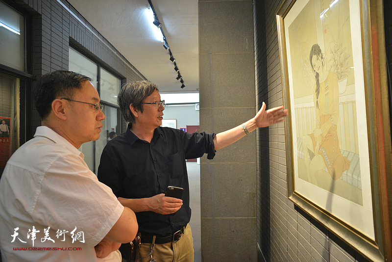 王春涛、李新禹在欣赏展出的画作
