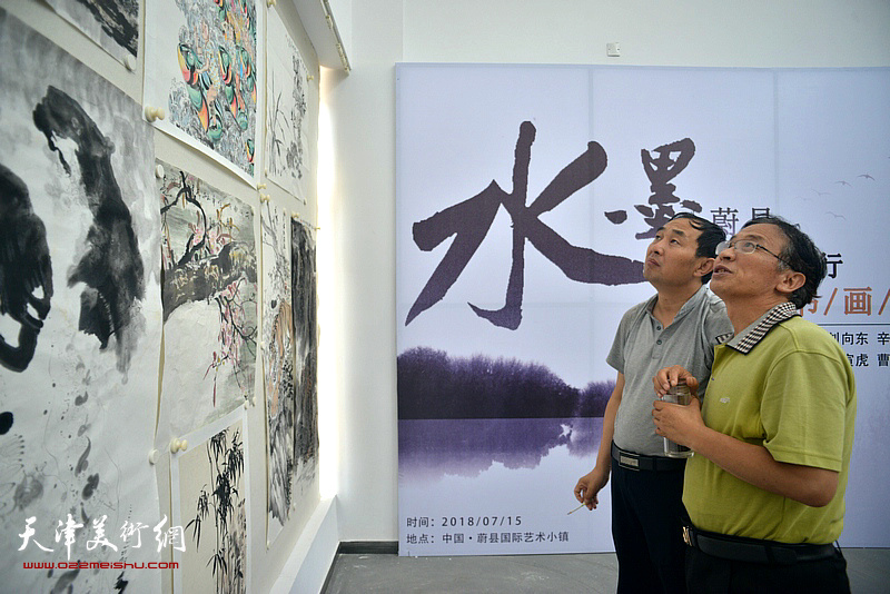 黄咏新、李清水观赏创作的作品。