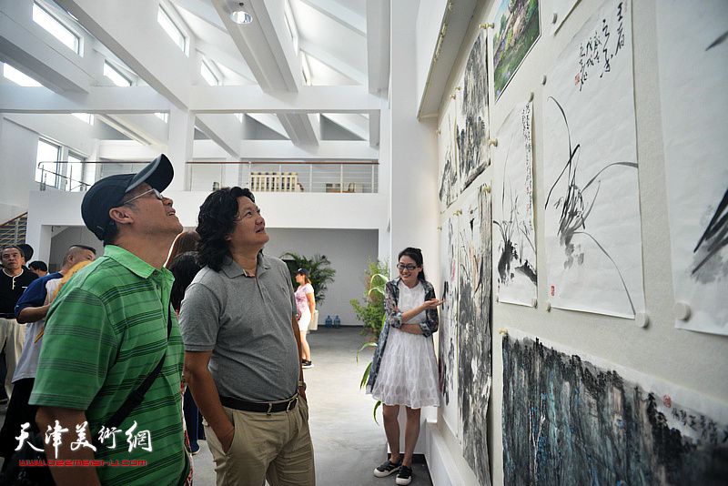 吕培桓、曹敬钢在观赏创作的作品。