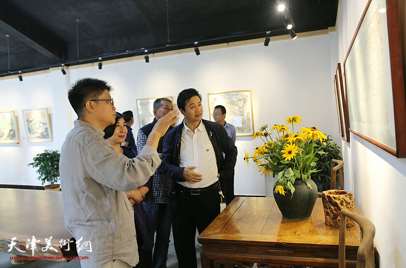 李旭飞在画展现场向嘉宾讲解自己的画作。