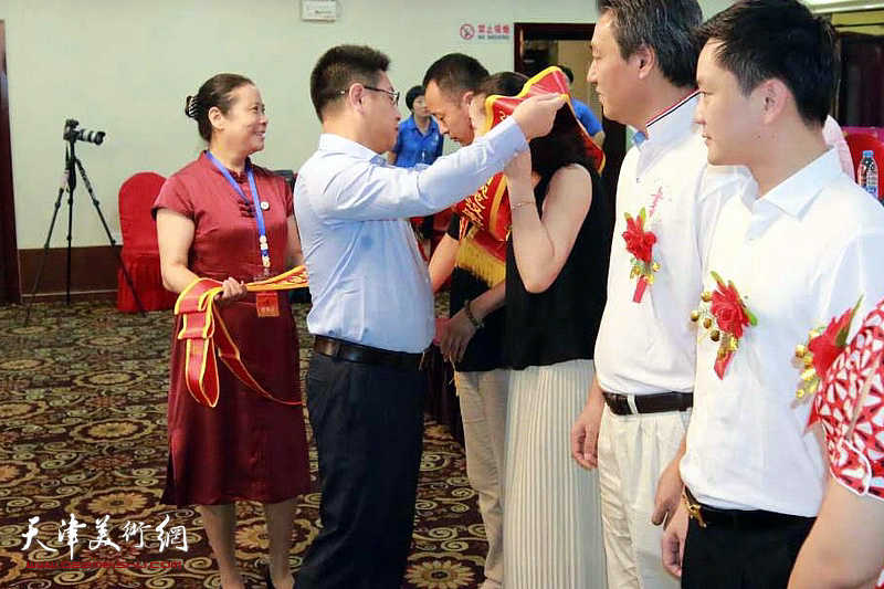 中国硬笔书法协会监事长熊洁英为获奖者佩戴绶带
