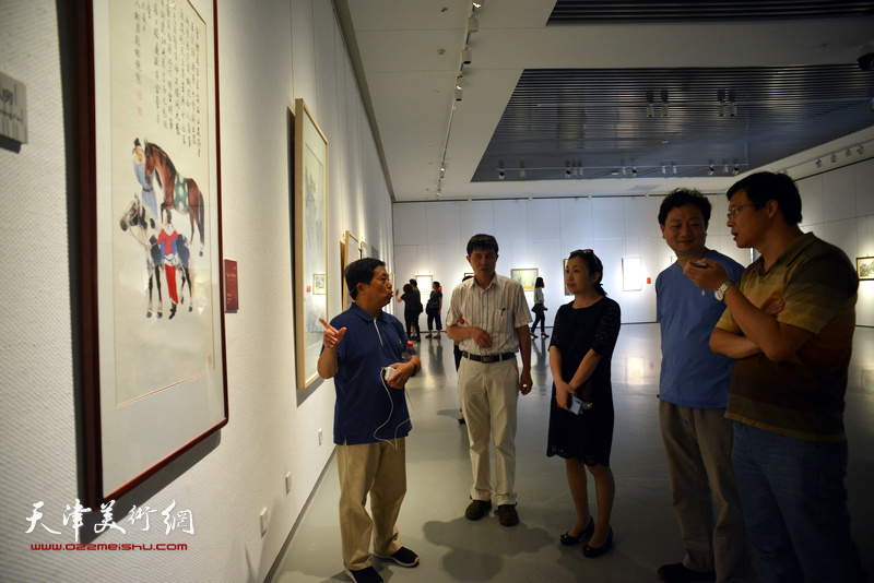 参展画家在展览现场与观众交流。