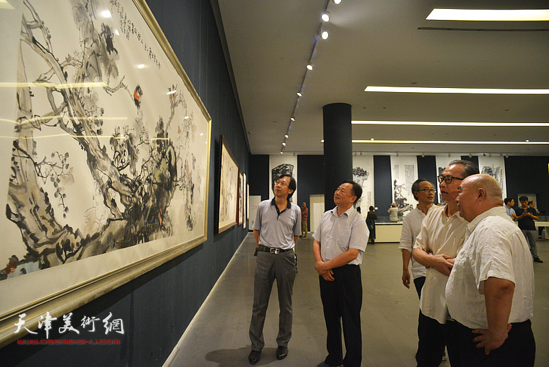 尹沧海与薛进文、陈福春、路洪明在画展现场观看作品。