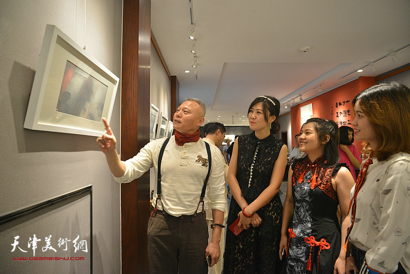 张俊国与弟子穆瑞欣、西贝、张爱在观赏展出的作品。