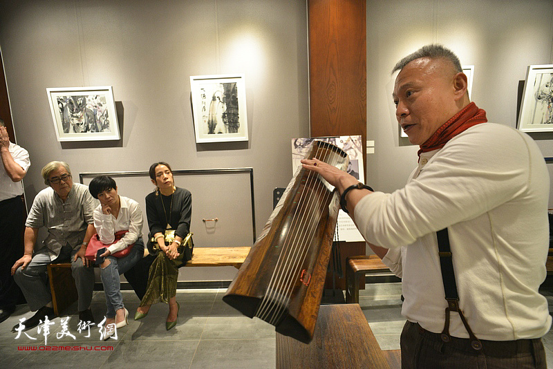 张俊国在展览现场介绍古琴。