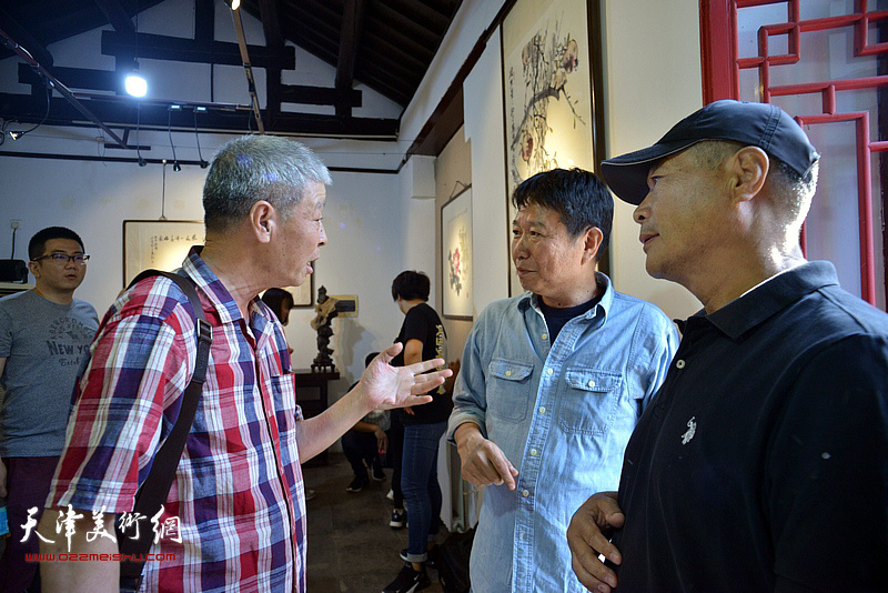 张庶丰、刘文生在画展现场交谈。