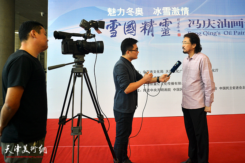 冯庆在画展现场接受媒体采访。