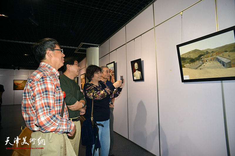 王书朋、何莉、齐宝成、刘小山在观赏展出的作品。