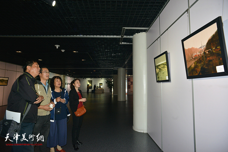 杨昆、曹昕、焦敏在观赏展出的作品。