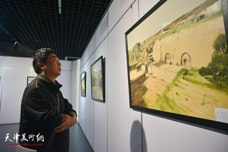 杨昆在观赏展出的作品。