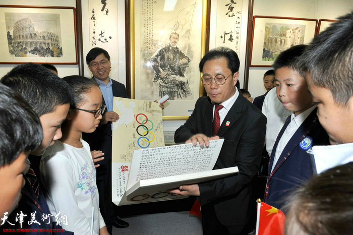 张大功展示他的《情系奥运环球之旅日记》向同学们讲述他宣传奥运的历程