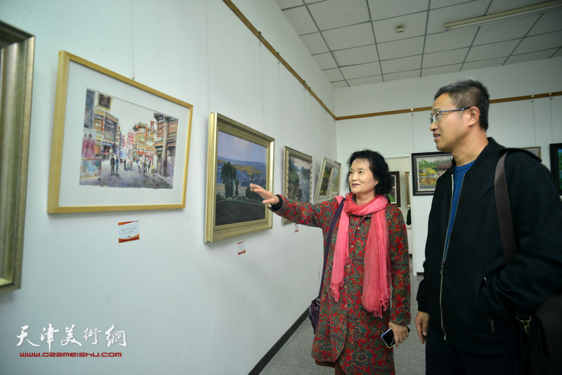 杨健、刁孟榕欣赏展出的画作。