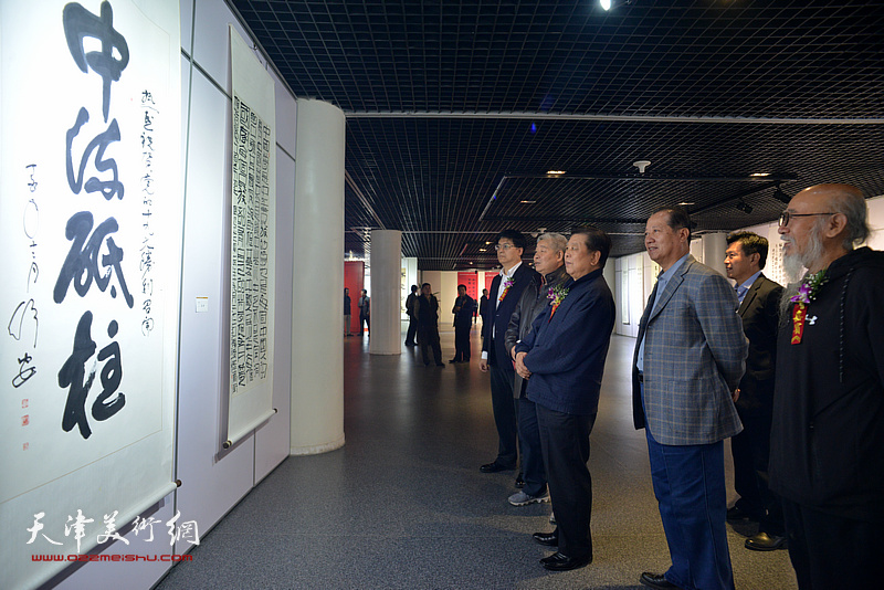 胡振民、寇江华、李岩、高杰、张未年、郭其元在观赏展出的作品。