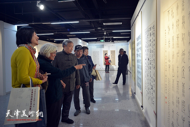 唐云来、刘春雨在展览现场与参展作者、观众观赏作品。