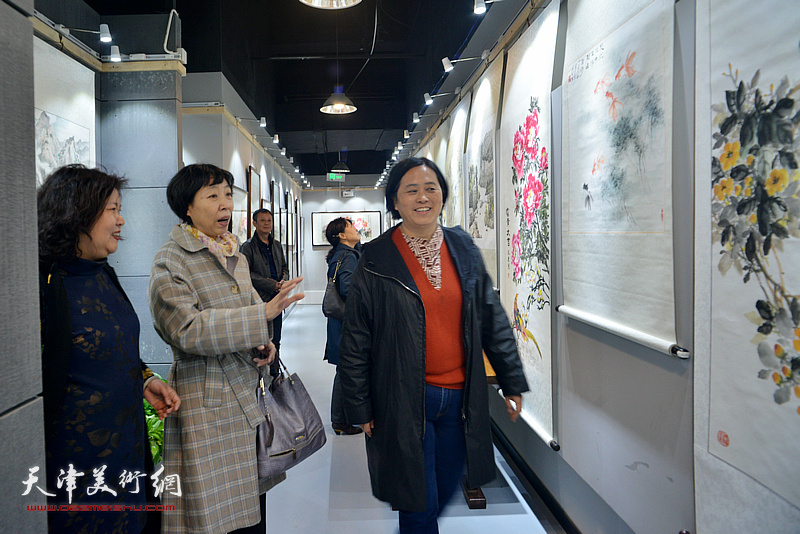 陈伟华陪同嘉宾观赏展出的作品。