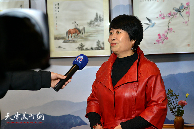 天津女子画院院长爱新觉罗·梦玉在画展现场接受媒体采访。