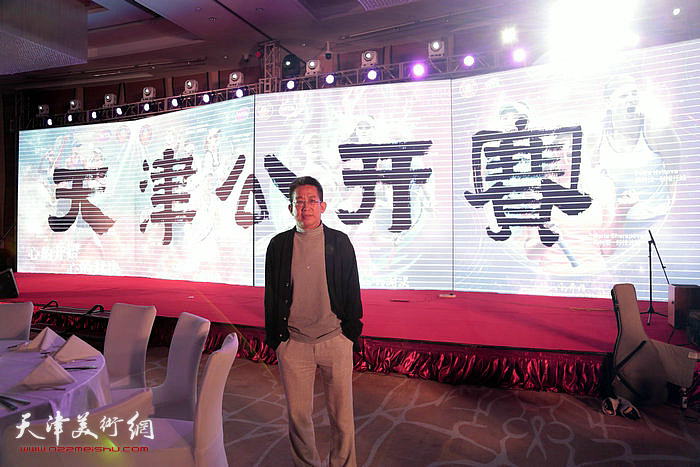 李毅峰在由他题写的“天津公开赛”前。