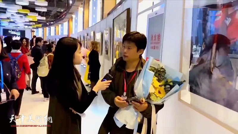 王海涛在画展现场接受媒体的采访。