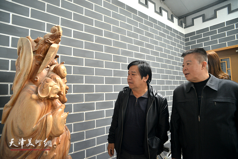 李耀春、潘晓鸥在观赏孙跃宇的木雕作品。