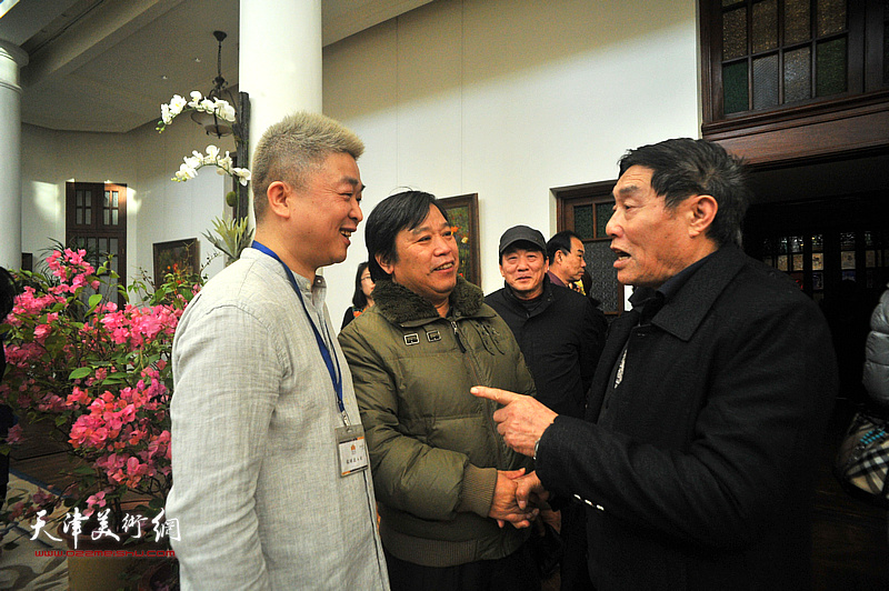 李耀春、窦宏伟与来宾在画展现场交流。