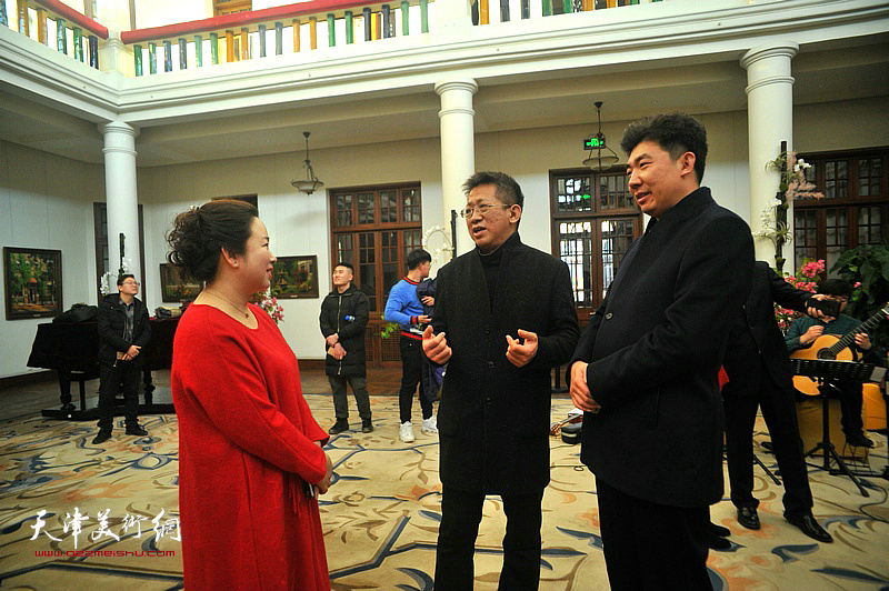 李毅峰、王健、孙娟在画展现场交流。