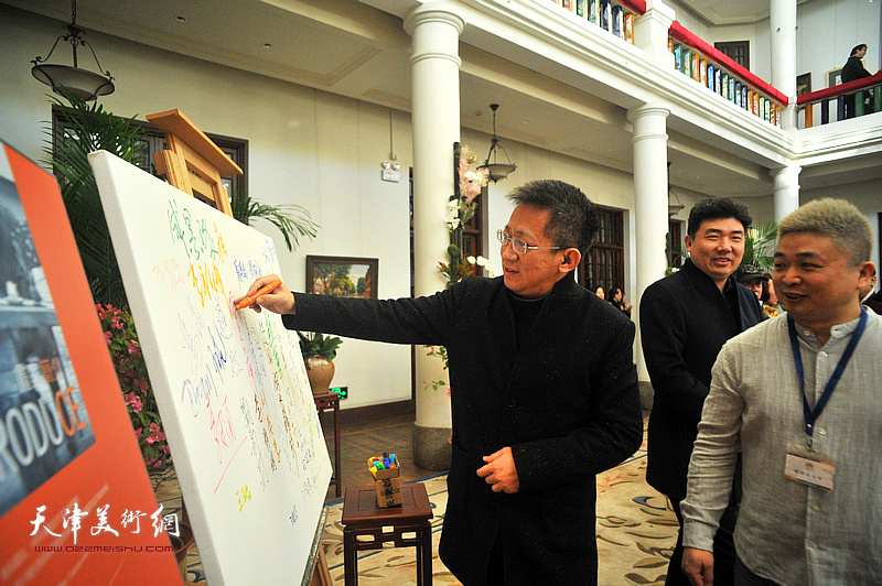 李毅峰在画展展牌签名。
