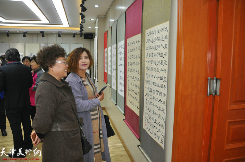 曹凤梅、石丽娜在观赏展出的作品。