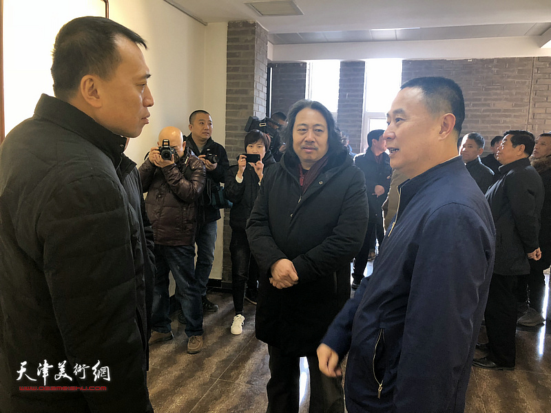 贾广健与张兵、周浩在画展现场交谈。