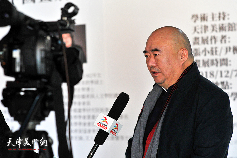 尹沧海在画展现场接受媒体采访。