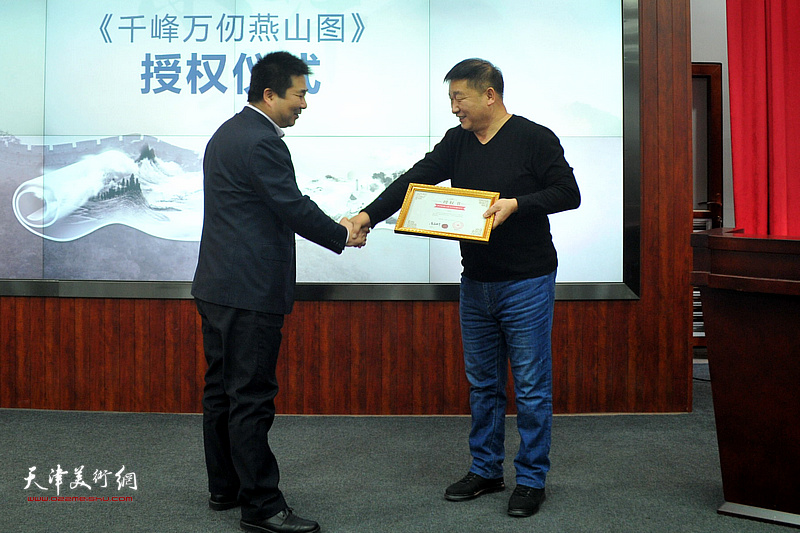 天津通广公司总经理李港向画家皮志刚颁发捐赠证书。