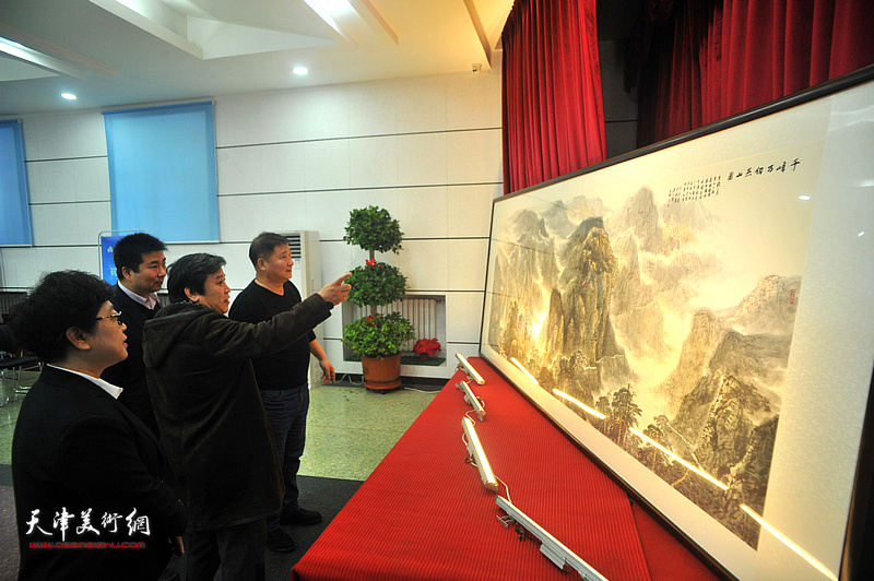 天津通广公司总经理李港、书记张桂兰与李耀春、皮志刚在发布会现场欣赏山水画《千峰万仞燕山图》。