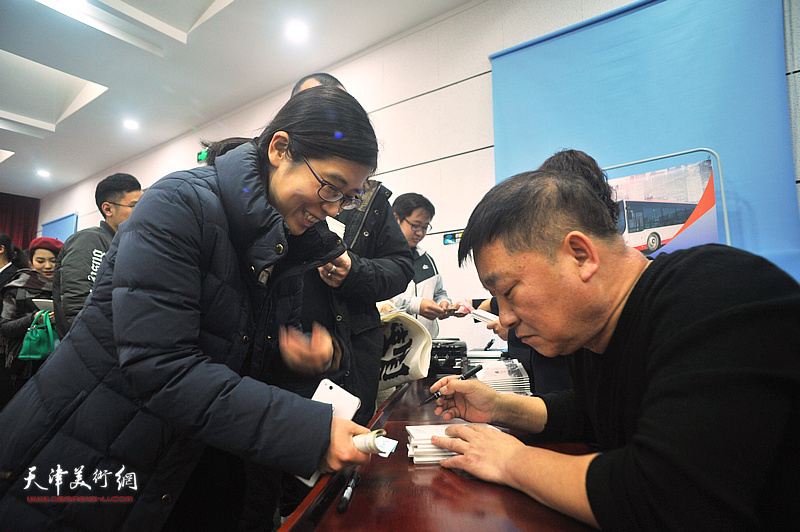 皮志刚在现场为市民在京津冀主题卡上签名留念。