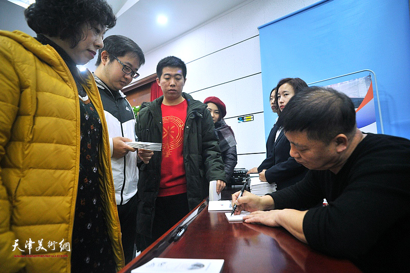 皮志刚在现场为市民在京津冀主题卡上签名留念。