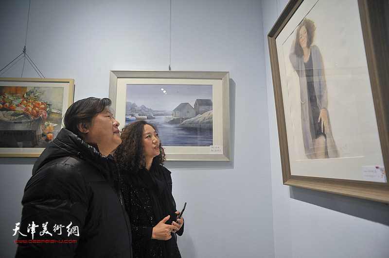 姜中立、陶香莲在画展现场观看作品。